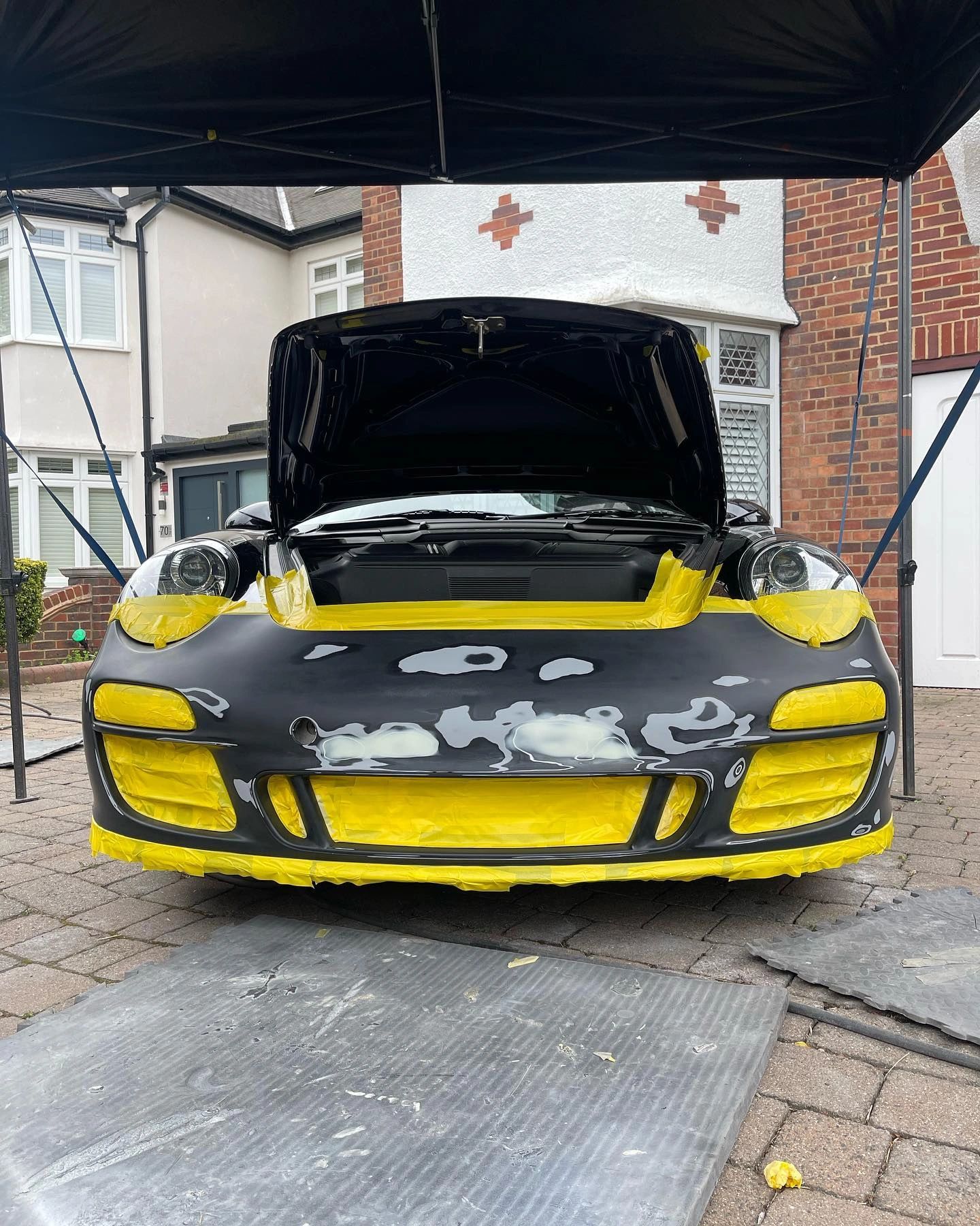Yellow custom sports car with black hood art